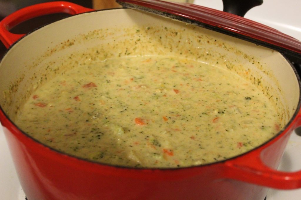 broccoli cheese soup in a red dutch oven