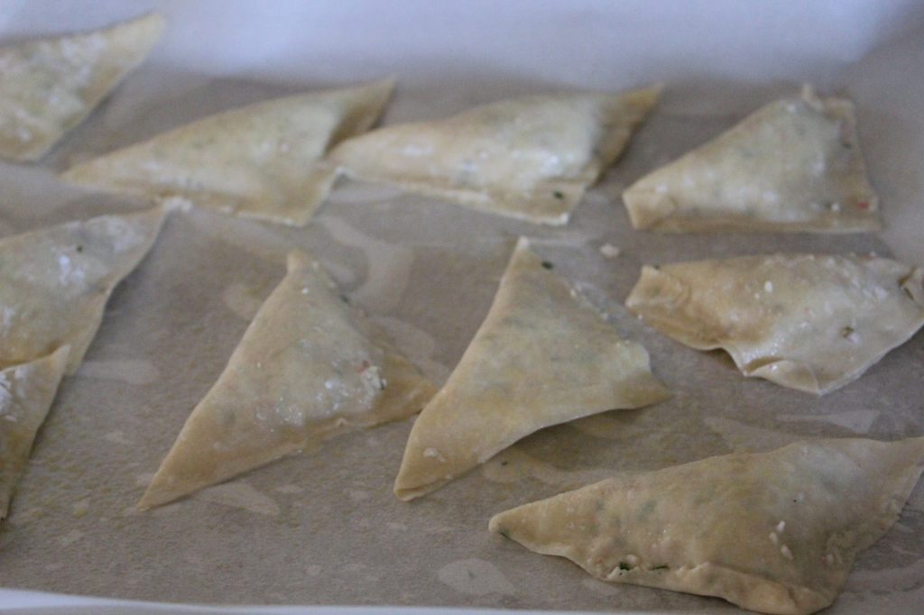 Assembled wontons on a baking sheet lined with parchment paper
