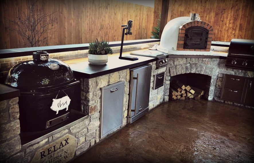 finished outdoor kitchen area with pizza oven, smoker, beer tap, fridge, grill