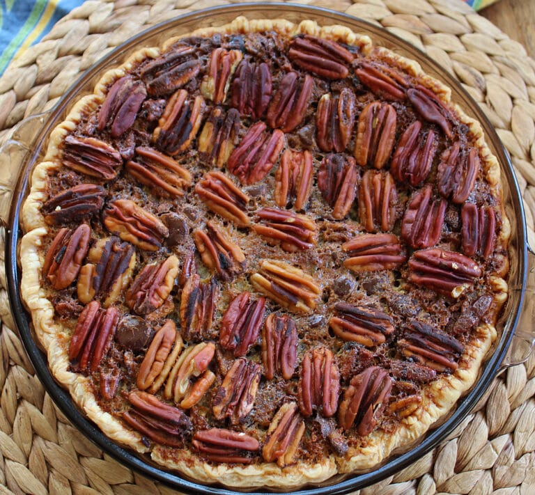 chocolate orange cointreau pecan pie baked in a glass pie plate on a woven place mat
