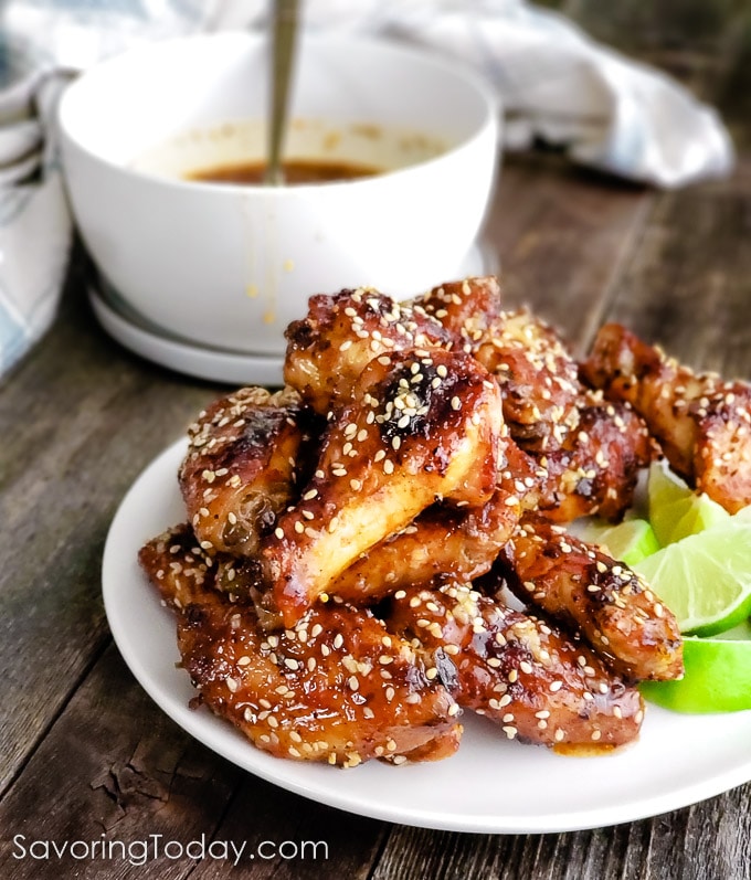 baked chicken wings with thai chili sesame sauce on a white plate on a table