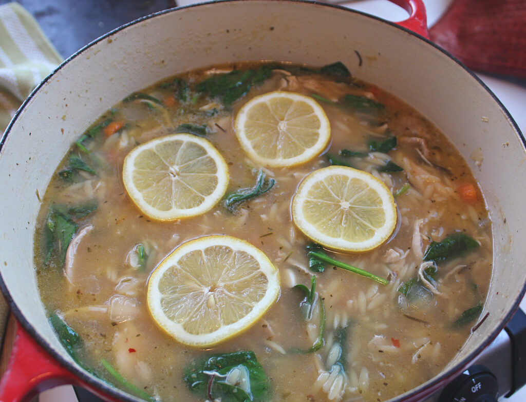 overhead picture of cooked lemon chicken orzo soup in a dutch oven