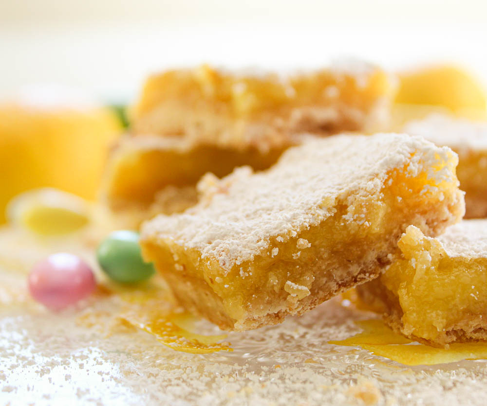 Lemon Bars with Almond Shortbread Crust on a crystal serving plate.