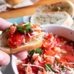 close up of bruschetta on toast over a bowl