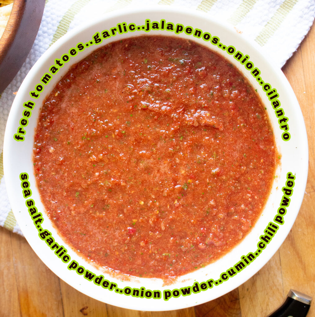 overhead picture of homemade salsa in a white bowl on a cutting board and dish towel