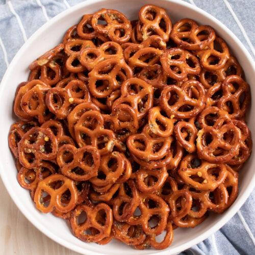 zesty Italian mini pretzels in a white bowl on a blue towel