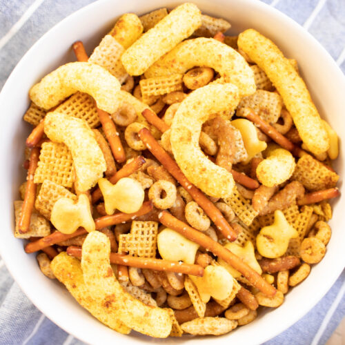 overhead picture of curry cheese puff chex mix in a white bowl