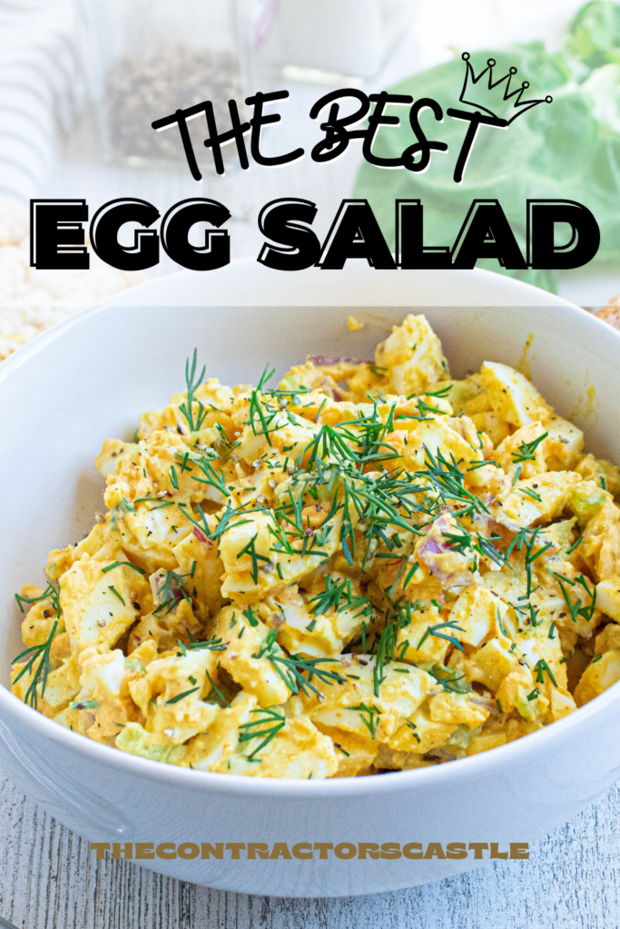 the best egg salad close up pin with fresh snipped dill on top in a white bowl