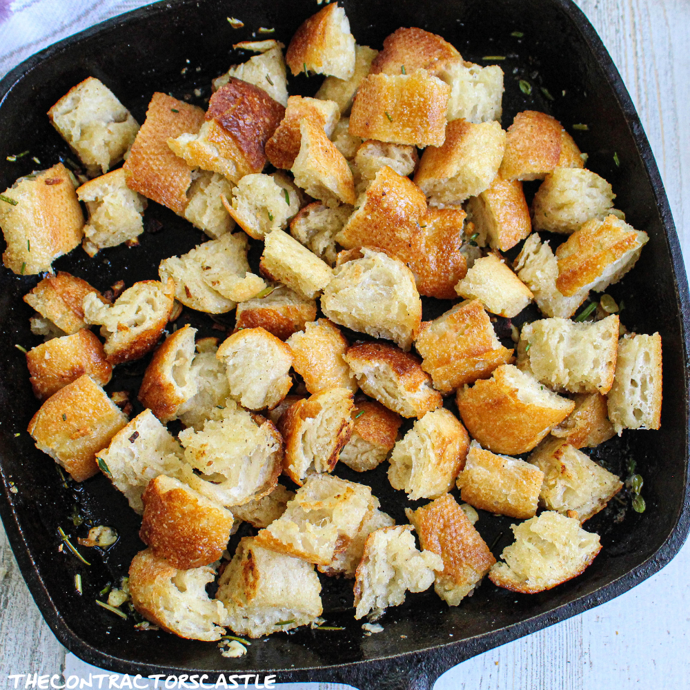 close up of stove top golden croutons in a cast iron skillet