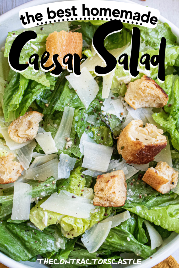 the best homemade Caesar Salad close up in a white bowl with homemade croutons, shaved parmesan cheese and fresh ground pepper