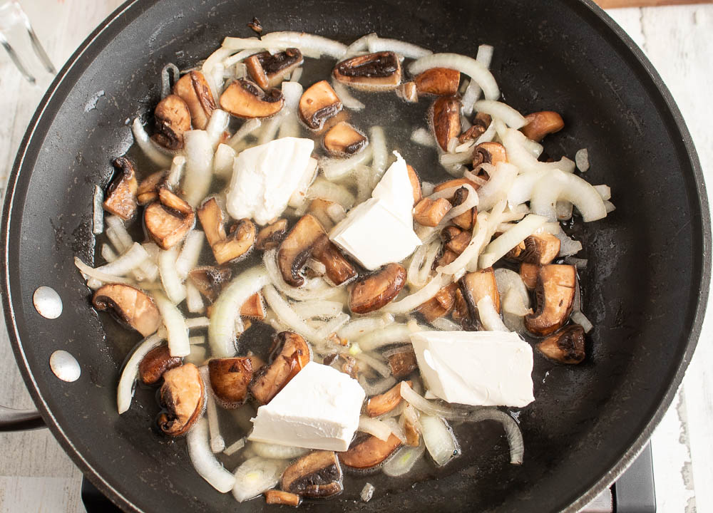 mushrooms, onions, garlic in a non stick skillet sauteing in butter with broth and cream cheese added.