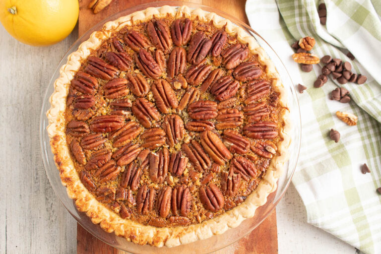 Whole Chocolate Orange Pecan Pie on a wooden serving board.