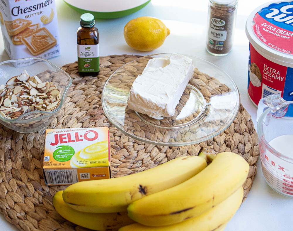 Best No Bake Banana Pudding Recipe with Cream Cheese ingredients on a bamboo placemat.