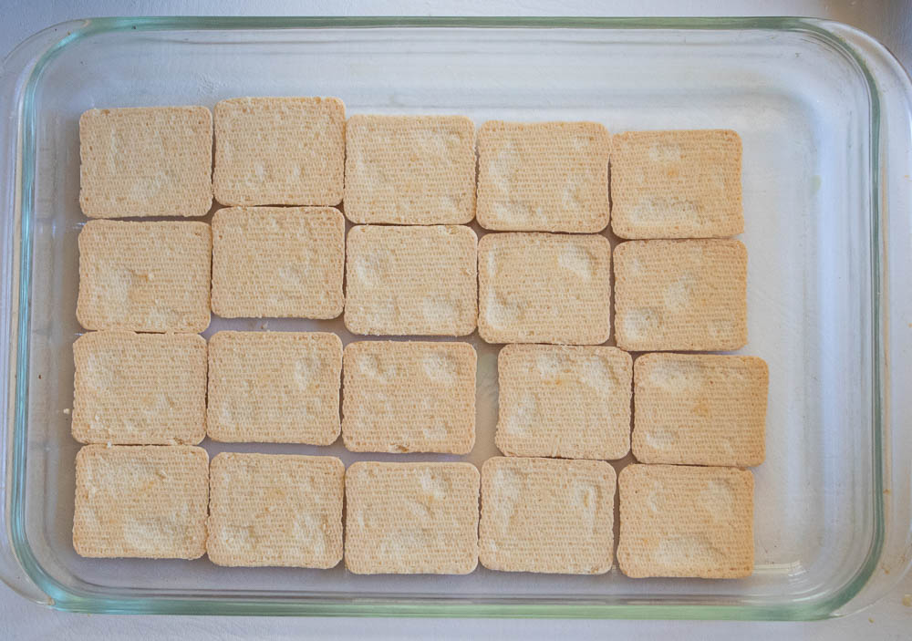 Layer of chessmen cookies in a glass pyrex casserole dish.