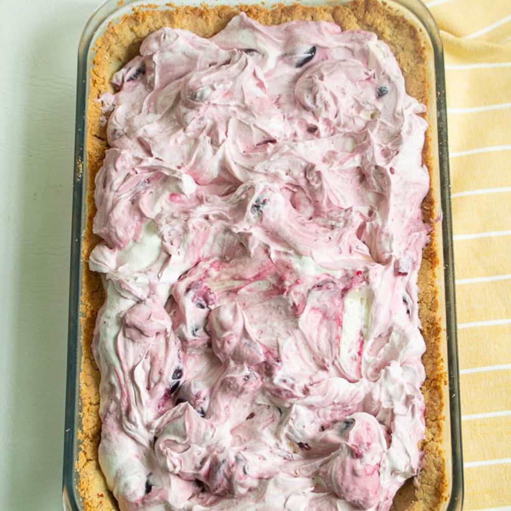 Creamy Chocolate cherry fluff with a shortbread crust in a clear glass baking dish before it's frozen.